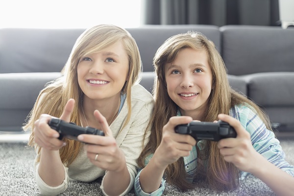 Sisters playing video games in living room